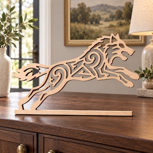 May include: A light brown wooden cutout sculpture of a wolf in a leaping pose. The wolf features intricate, openwork scroll and swirl patterns throughout its body, mounted on a flat, rectangular wooden base for stability on a flat surface.