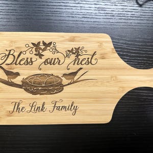 Puede incluir: Una taza de cerámica blanca con un asa negra y el texto "But First, Coffee" en negro, en negrita. La taza está sobre una superficie blanca.