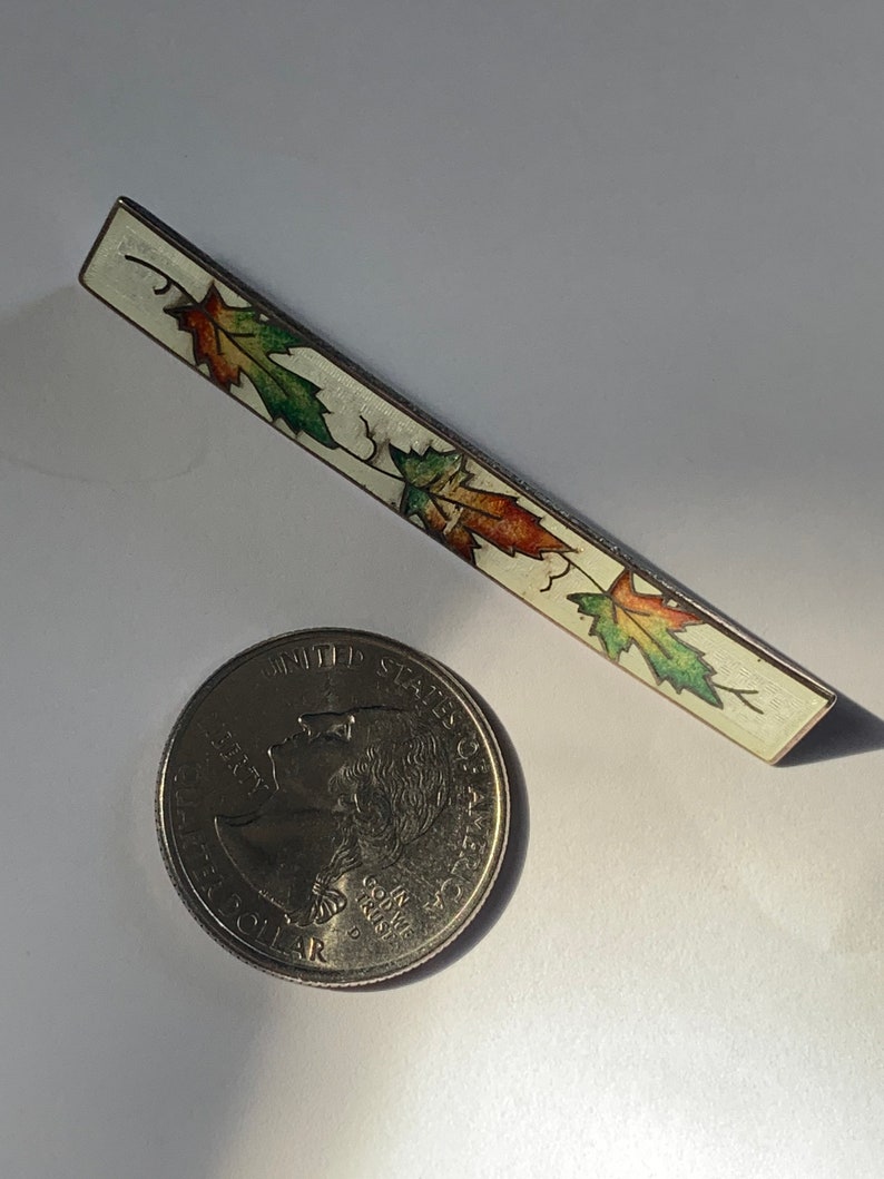 Vintage sterling silver brooch with enameled maple leaf motif