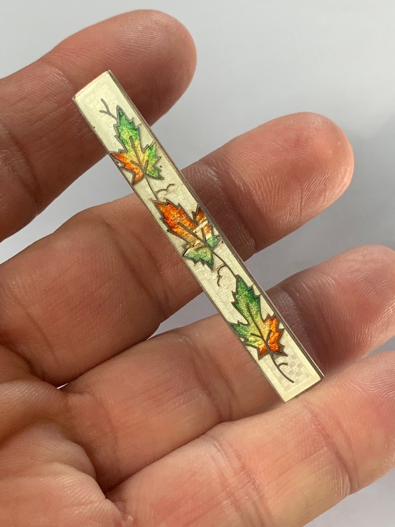 Vintage sterling silver brooch with enameled maple leaf motif
