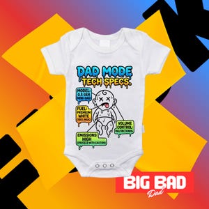 May include: White baby bodysuit featuring the text "DAD MODE TECH SPECS". The design includes a baby graphic with technical details like "MODEL: 0.5 GEN MINI-DAD" and "FUEL: PREMIUM WHITE (100% MILK)". The bottom reads "BIG BAD Dad".