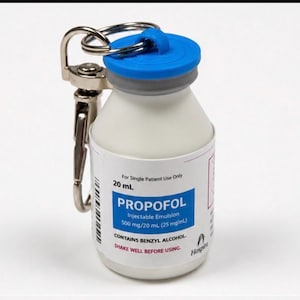 Può includere: Un flacone bianco con tappo blu e clip in metallo argentato. Il flacone ha un'etichetta con la scritta "PROPOFOL Injectable Emulsion 500 mg/20 ml (25 mg/mL)". Il flacone è da 20 ml.