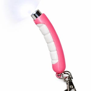 May include: A pink and white LED keychain flashlight with a bright beam of light. The flashlight has a curved handle with a white grip and a silver metal clip for attaching to keys or a bag.