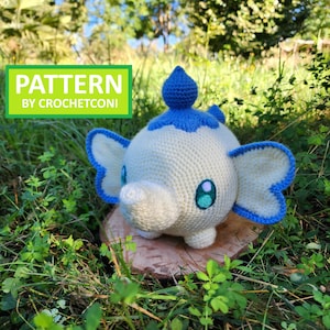 May include: A crocheted plush toy in the shape of a cartoon elephant, with white, blue, and teal accents. The toy has large, blue-trimmed ears and a blue headpiece. The text "PATTERN BY CROCHETCONI" is in a green box.