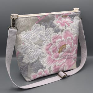 Bolso bandolera tipo bandolera, muy popular y único, confeccionado a mano en seda pura con un estampado de peonías en forma de abanico de papel e hilos dorados y plateados.
