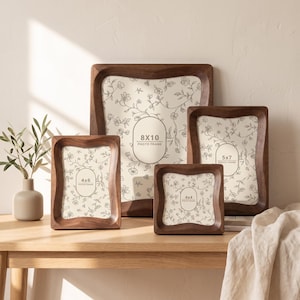 May include: A set of four dark brown wooden photo frames with curved edges, featuring cream-colored inserts with a delicate black floral line drawing pattern. The frames are labeled with sizes 8x10, 5x7, 4x6, and 4x4 inches in oval or rounded rectangular text boxes.