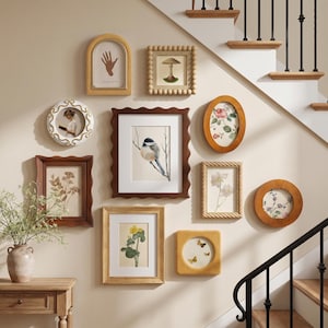 May include: A gallery wall arrangement featuring ten diverse picture frames in various shapes and finishes, including wood, white, and textured styles. The frames contain botanical prints, a bird illustration, a hand drawing, and butterfly art.
