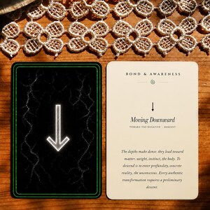 May include: Two rectangular cards. The left card is black with a white downward arrow and green border. The right card is cream-colored with the text BOND & AWARENESS, Moving Downward, TOWARD THE NEGATIVE - DESCENT, and a paragraph of descriptive text.
