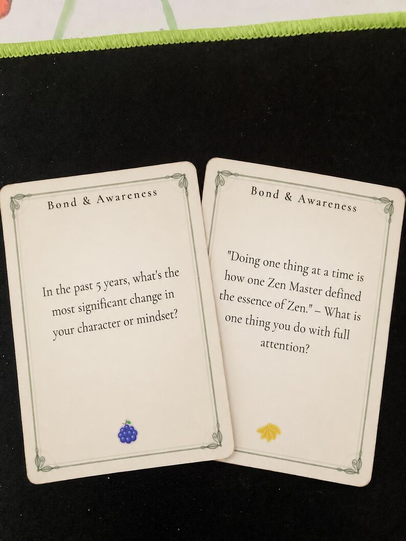 May include: Two off-white rectangular cards titled Bond & Awareness. The left card asks, In the past 5 years, what's the most significant change in your character or mindset? with a blue grape icon. The right card features a quote about Zen.