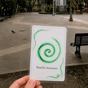 May include: A rectangular white card featuring a vibrant green spiral graphic centered on the front. Below the spiral, the text Bond & Awareness is printed in a clear black serif font. The card is encased in a thin, transparent plastic sleeve.