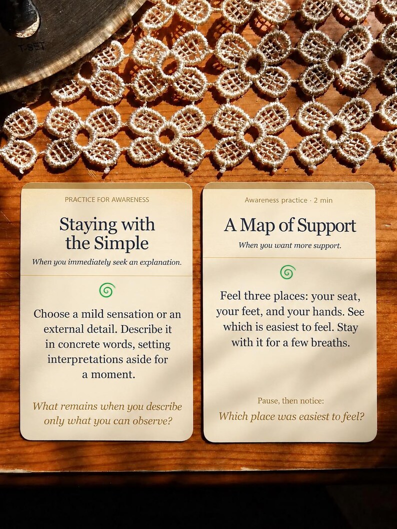 May include: Two rectangular off-white cards with dark text and green spiral icons. The left card is titled Staying with the Simple, and the right card is titled A Map of Support. Both cards contain instructional text for awareness practice.