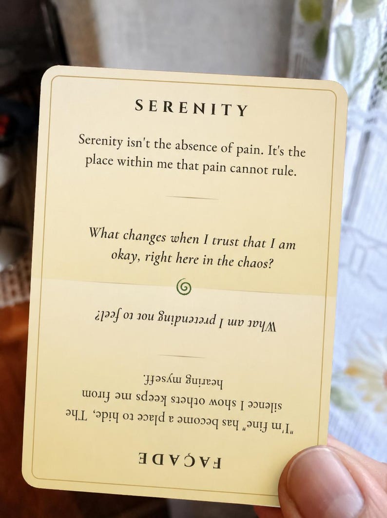 May include: A rectangular cream-colored card with rounded corners featuring the word SERENITY at the top, followed by text about pain and trust. Below a green spiral icon, the card is inverted with the word FA&Ccedil;ADE and text about silence.
