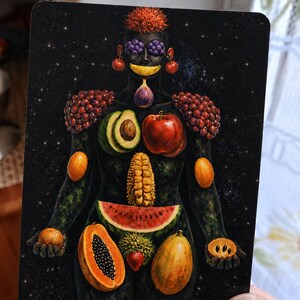 May include: A rectangular art card featuring a dark, starry background with a human figure composed of various fruits. The figure has grapes for eyes, a banana mouth, a fig chin, avocado and apple chest, corn torso, and watermelon hips.