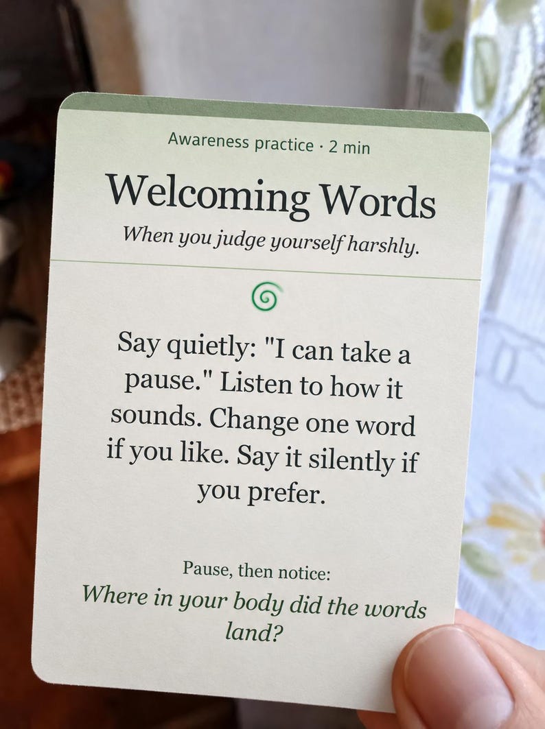 May include: A rectangular off-white card with a green top border featuring the text Awareness practice 2 min, Welcoming Words, When you judge yourself harshly, and instructions to say I can take a pause and notice body sensations.