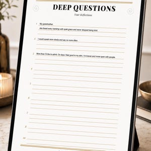 May include: A digital tablet displaying a white page titled DEEP QUESTIONS Your Reflections with numbered lines for writing. The bottom includes the text Bond & Awareness A SPACE FOR THOSE WHO DARE TO LOOK WITHIN with gold line accents.