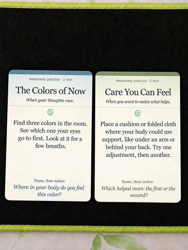 May include: Two rectangular awareness practice cards. The left card is titled The Colors of Now and instructs to find three colors in the room. The right card is titled Care You Can Feel and instructs to place a cushion or folded cloth for support.
