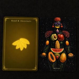May include: Two rectangular cards. The left card is dark gold with the text Bond & Awareness and a yellow leaf icon. The right card features a dark, starry background with a human figure composed of various fruits, including grapes, apples, and papaya.