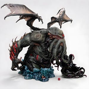 May include: A detailed sculpture of a monstrous creature with large, tattered wings, a tentacled face, and a massive body emerging from stylized blue waves. The figure is primarily dark green and gray, with red accents. A red die is visible.