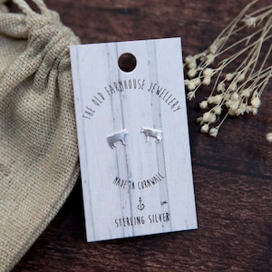 May include: Sterling silver cow stud earrings on a white card with the text "The Old Farmhouse Jewellery" and "Made in Cornwall".