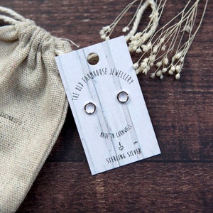May include: Sterling silver hoop earrings on a card printed with "The Old Farmhouse Jewellery, Made in Cornwall". A beige drawstring bag and dried flowers are also in the image.