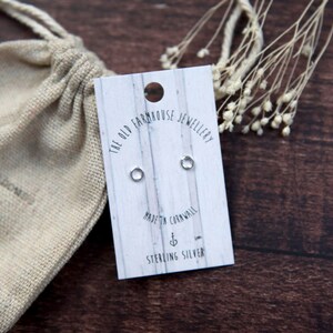 May include: A pair of sterling silver circle earrings on a white card with the text "The Old Farmhouse Jewellery" and "Made in Cornwall".