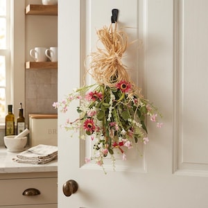 May include: A white ceramic mug with a black handle and the text "But First, Coffee" in a bold, black font. The mug is filled with a dark liquid, likely coffee, and sits on a light-colored surface.