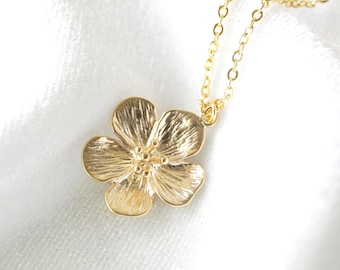 May include: A gold necklace with a delicate flower pendant. The flower is detailed and has a textured finish.
