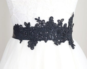 May include: A black lace sash with beaded embellishments, perfect for adding a touch of elegance to a wedding dress or other formal attire.