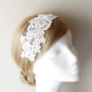 May include: White lace headband with pearl accents. The headband is delicate and features a floral design.