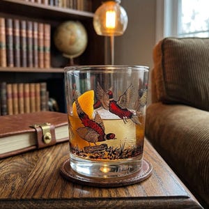 May include: A white ceramic mug with a black handle and the text "But First, Coffee" in a bold, black font. The mug is set against a neutral background, highlighting its simple design.