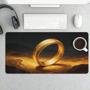 May include: A white ceramic mug with a black handle and the text "But First, Coffee" in a bold, black font. The mug is set against a blurred background, suggesting a cozy setting.