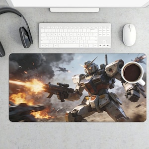 May include: A rectangular desk mat featuring a detailed illustration of a Gundam robot in a battle scene, firing a weapon. The robot is predominantly white, red, and blue, with a dynamic action pose. A cup of coffee sits on the mat.
