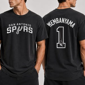 Pu&ograve; includere: Una t-shirt nera a maniche corte con il logo e la scritta San Antonio Spurs sul davanti. Il retro mostra il nome Wembanyama in un carattere arcuato sopra il numero 1, che include una firma grafica in inchiostro bianco sul tessuto nero.