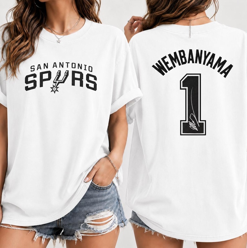 Pu&ograve; includere: Una t-shirt bianca a maniche corte con il logo e la scritta San Antonio Spurs sul davanti. Il retro della maglietta mostra il nome Wembanyama in nero sopra il numero 1, che include un piccolo grafico di una firma all'interno della cifra.