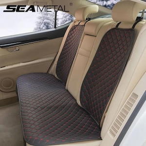 Puede incluir: Fundas de asiento de coche negras con costuras de diamante rojas. Las fundas están instaladas en un coche con asientos de cuero beige. La marca "SEAMETAL" es visible en la esquina superior izquierda.