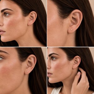 May include: A small gold stud earring in the shape of a cross. The earring is worn in the earlobe, featuring a simple, polished metal design that sits flush against the skin. The cross is minimalist in size and gold in color.