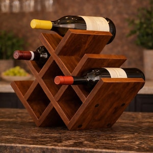 Puede incluir: Un botellero de madera oscura con diseño de rombos, que contiene tres botellas de vino. El botellero está hecho de madera marrón oscura y se encuentra sobre una encimera. Las botellas tienen tapones amarillos y rojos.