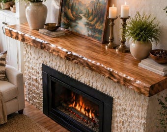 May include: A cozy living room scene featuring a fireplace with a live-edge wooden mantel. The fireplace has a black frame and a stone facade. The room is decorated with neutral tones, including a beige sofa, a round coffee table, and a woven rug. Decorative items include vases, candles, and a landscape painting.