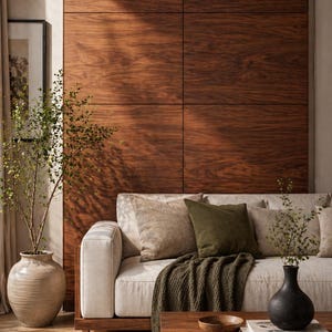 Könnte beinhalten: Ein modernes Wohnzimmer mit cremefarbenem Sofa, olivgrünen und beigefarbenen Kissen und einer dunkelgrünen Decke. Ein Holztisch trägt eine Schale und Bücher. Der Hintergrund ist eine große Wand mit dunklen Holzpaneelen.