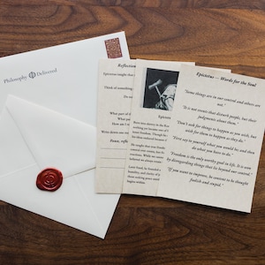 Puede incluir: Una taza de cerámica blanca con un asa negra y el texto "But First, Coffee" en negro, con una fuente de estilo manuscrito. La taza está sobre una superficie blanca.