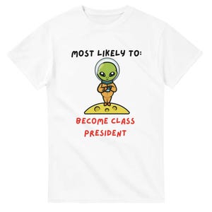 May include: White t-shirt featuring a cartoon alien in an orange spacesuit, standing on a yellow moon. The text above reads "MOST LIKELY TO:" and below, "BECOME CLASS PRESIDENT" in red.