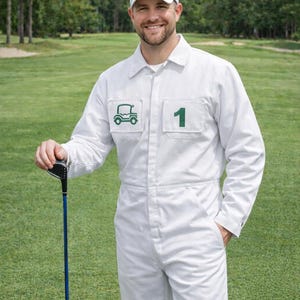 以下が含まれることがあります： 白いジャンプスーツとグリーンのロゴが入った白いキャップをかぶり、緑のゴルフコースでゴルフクラブを持っている人。ジャンプスーツにはグリーンのゴルフカートのロゴと数字の1が入っています。