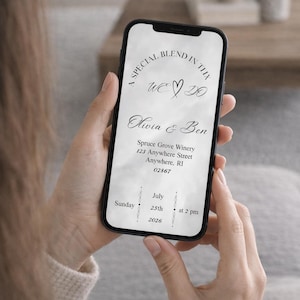 Op de afbeelding: Een smartphone toont een trouwuitnodiging met elegant handschrift. De uitnodiging bevat de tekst "A Special Blend In This", "We Do", en de namen Olivia & Ben. De datum is 25 juli 2026 om 14:00 uur.