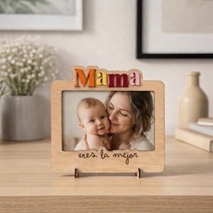 May include: Wooden photo frame with the word "Mama" in colourful letters at the top. The frame holds a photo of a mother and baby. The text "eres la mejor" is written at the bottom of the frame.