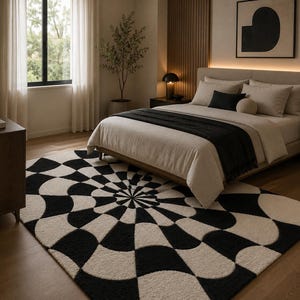 May include: A rectangular area rug featuring a high-contrast black and cream geometric pattern with curved, radiating shapes that create a circular, optical illusion effect. The rug is made of a textured material and covers the floor in a bedroom.