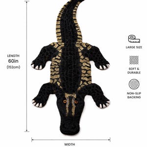 May include: A large, black and gold alligator rug, measuring 152cm long and 84cm wide. The rug features a textured design and a non-slip backing. It is described as soft and durable.