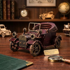 May include: A detailed wooden model of an antique touring car with a custom finish. The car is a deep burgundy color with brass-colored accents. The model has intricate details, including the wheels, headlights, and radiator. The sign reads "Antique Touring Car Model - Custom Finish - circa 1912."