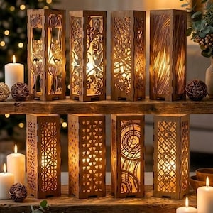 May include: A collection of wooden candle lanterns with detailed, laser-cut patterns. The lanterns, lit from inside, sit on a wooden shelf alongside candles and decorations. The warm light creates a cosy and inviting atmosphere.