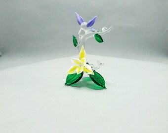 Frühlingslila Kolibri auf Ast mit gelber Blüte. Alles aus Glas. Handgefertigt. Muttertagsgeschenk