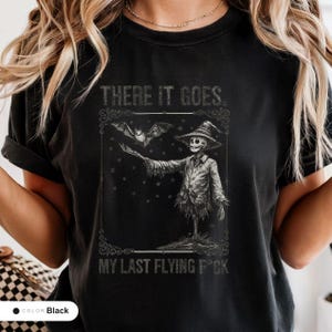 Model wearing a black t-shirt printed with "Graveyard Bat Catcher" across the chest.